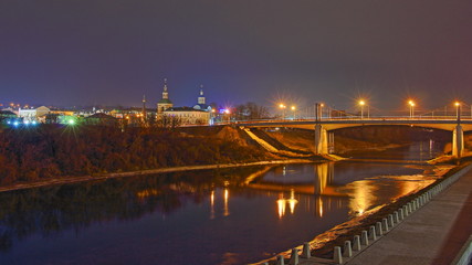 Russia, Smolensk famous landmark Uspensky Bridge across Dnieper river, embankment Park and Church, beautiful wide autumn evening view from City Observation deck on blue sky background