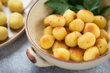 Close-up of pan fried stuffed potato gnocchi in a bowl, selective focus, studio shot