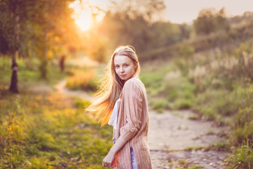 Cute caucasian girl with long hair in field,sunset