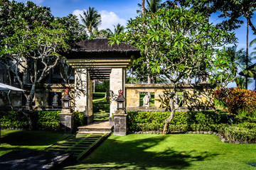 balinese doorway and architecture and fountains with trees and flora surrounding it