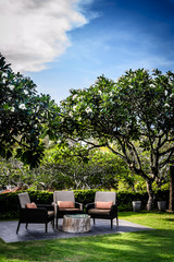 outdoor garden seating in a garden with pillows and many trees