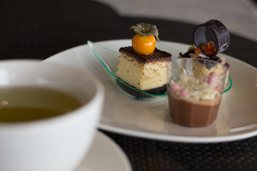 afternoon tea of small chocolate cakes and chocolate pudding on a white plate