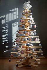 eco-friendly creative Christmas tree made of boards. alternative Christmas tree decorated with toys...