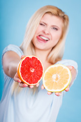 Woman holding red and green grapefruit