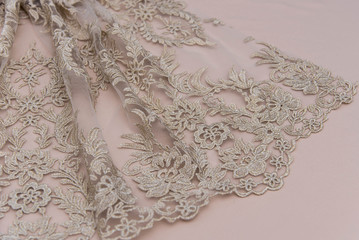 Texture lace fabric. lace on white background studio. thin fabric made of yarn or thread. a background image of ivory-colored lace cloth. Beige lace on beige background.