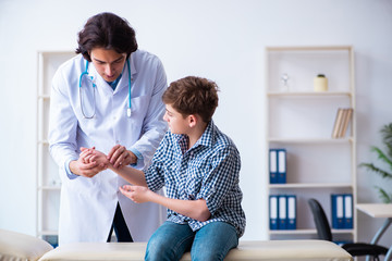 Hand injured boy visiting young male doctor