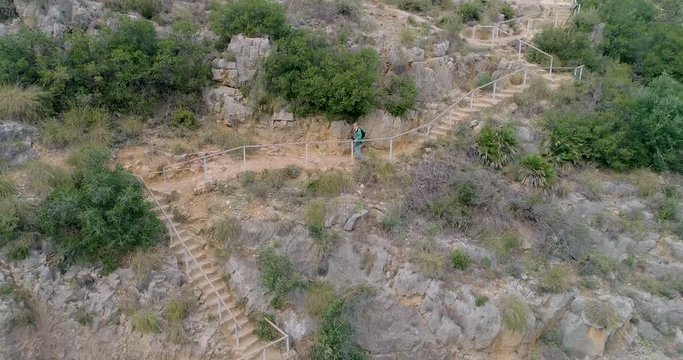 persona mayor de barba blanca senderista desciente barranco por escaleras de piedra