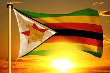 Zimbabwe flag weaving on the beautiful orange sunset with clouds background - obrazy, fototapety, plakaty