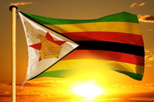 Zimbabwe flag weaving on the beautiful orange sunset with clouds background