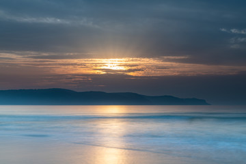 Fototapeta na wymiar Clouds, Sun Rays and Smoke Haze Sunrise Seascape