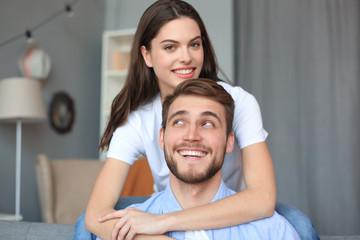 Obraz premium Beautiful woman with boyfriend spending quality time together on sofa at home in the living room.