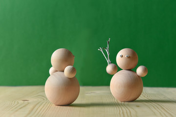 A wooden toy gives a bouquet to his beloved. Valentine's day concept.