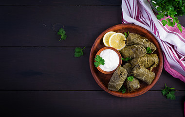 Dolma. Stuffed grape leaves with rice and meat on dark table. Middle eastern cuisine. Top view, overhead, copy space