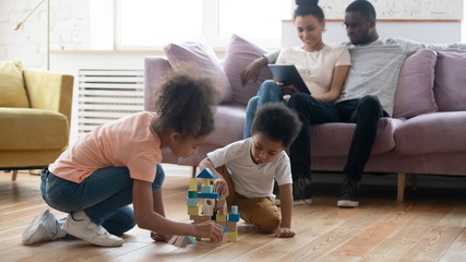 Little biracial siblings play with building blocks at home