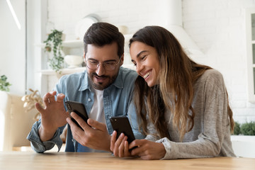 Young couple using smartphones share social media news at home - Powered by Adobe