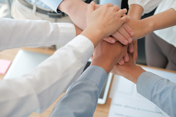 Obraz na płótnie Canvas businessman businesswoman joining united hand, business team touching hands together. unity teamwork partnership concept.