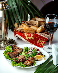 fried meat with onion and lemon and glass of red wine