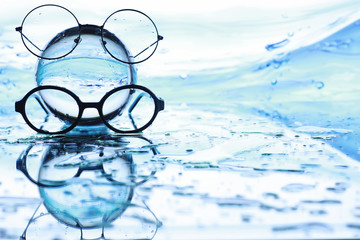 Tools for vision correction. Glasses and lenses with diopters on the background of splashes and...