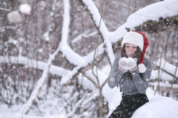 Girl in a winter park in snowfall