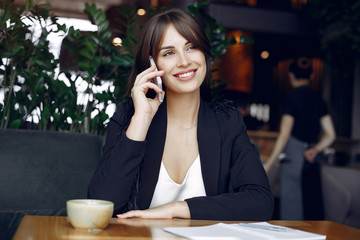 Woman working with a notebook. Lady with a coffee. Businesswoman use the phone