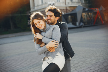 Cute couple in a spring city. Lady with long hair. Man in a black jacket