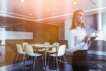 Blonde woman in gray and white marble kitchen