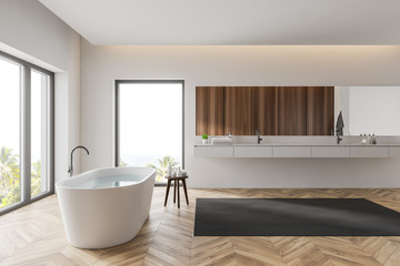 Obraz na płótnie Canvas Side view of white bathroom with sink and tub
