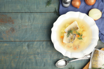 Delicious fish soup served on blue wooden table, flat lay. Space for text