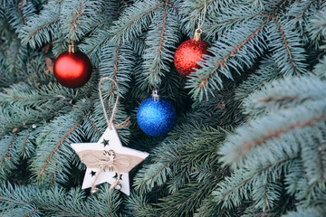 Christmas toy on the branches of a New Year tree. Christmas tree decorated with a festive ball and...