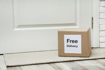 Parcel with sticker Free Delivery on rug indoors, space for text. Courier service