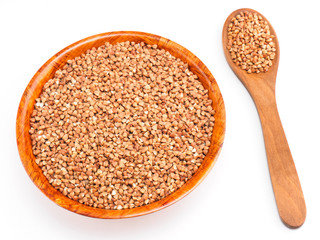 Buckwheat groats in bamboo bowl and wooden spoon on white background. Weight loss concept