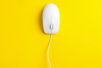 Modern wired optical mouse on yellow background, top view