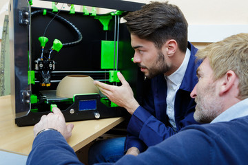 two male engineers working with 3d printer