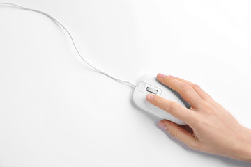 Woman using modern wired optical mouse on white background, top view