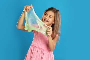 Little girl with slime on blue background
