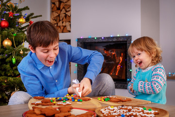 Happy children preparing cookies for Christmas and New Year at home