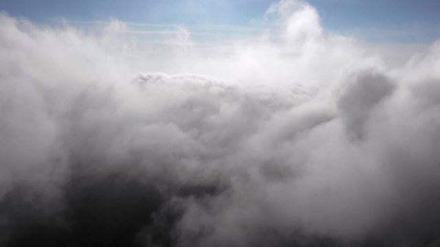 Flying between thick puffy clouds. Aerial cloudscape. Background