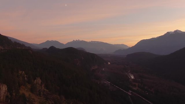 Aerial Panoramic View of Sea to Sky Hwy in the beautiful valley surrounded by Canadian Mountains during colorful autumn sunset. Taken near Squamish, BC, Canada.