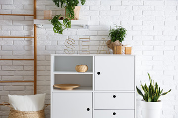 Chest of drawers in stylish room interior