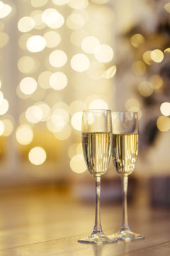 Two glasses of champagne with lights in the background. focus on near glass.