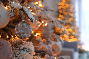 Christmas tree branch with balls indoors, closeup. Festive interior decoration