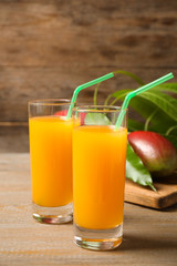 Fresh delicious mango drink on wooden table