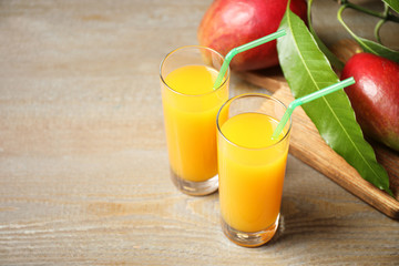 Fresh delicious mango drink on wooden table. Space for text