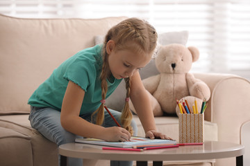 Little girl drawing in child psychotherapist's office