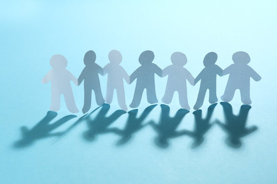 Paper people chain on light blue background. Unity concept