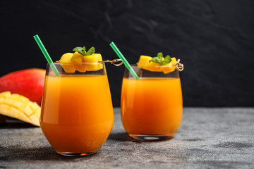 Fresh delicious mango drink on grey table