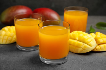 Fresh delicious mango drink on grey table