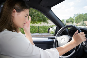 Naklejka premium woman having headache in a car