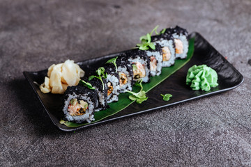 Various kinds of sushi served on black stone