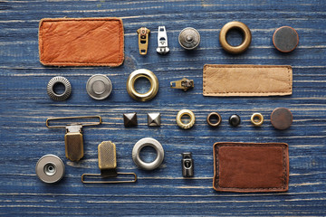 Flat lay composition with garment accessories for jeans on blue wooden background